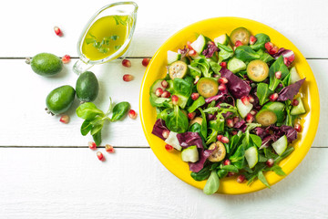 Fresh salad with cucumbers, feijoa, pomegranate and salad leaves