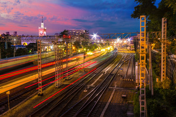 Long exposure aerial view of the Sochi railway station with motion blurred trains at twilight,...