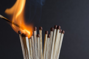 Burning matchstick on black background