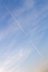 Blue sky and a plane with vapor trail.