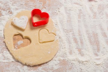 on a wooden board dough for Christmas cookies, rolling pin, branches of a Christmas tree, cookie...