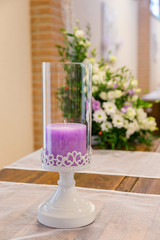 Portacandela con candela decorativa per eventi con fiori sullo sfondo