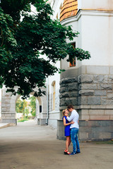Fototapeta na wymiar loving young couple walking around town man in white shirt and girl in blue dress