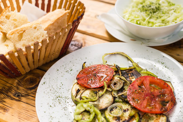 Grilled vegetables and cabbage salad, bread on a wooden table. The concept of healthy eating. Close-up.