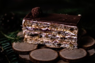 Christmas tasty cake on dark wooden background with spruce decoration. 