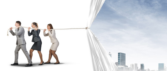 Young businesspeople working in collaboration and pulling white advertisement banner