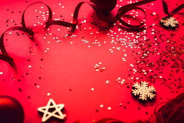 Christmas red glowing decorative balls and ribbons on red toned background. Winter seasonal flatlay, copyspace for text