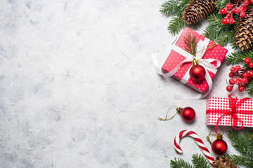 Red christmas present box, fir tree branch and decorations.