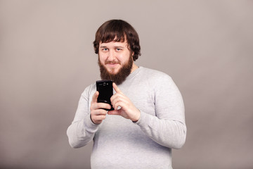 man with beard photographing with a smartphone