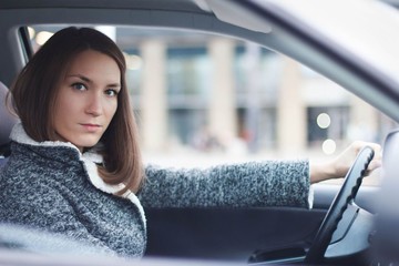 Young woman driving her car in the city