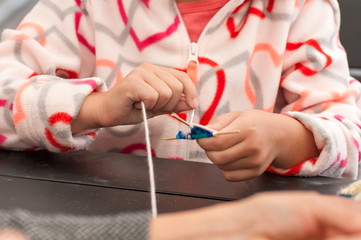  teacher teaches children how to weave a mandala out of thread during the fair in Ukraine