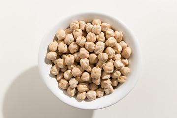 Chickpeas legume. Top view of grains in a bowl. White background