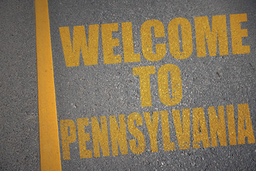 asphalt road with text welcome to pennsylvania near yellow line.