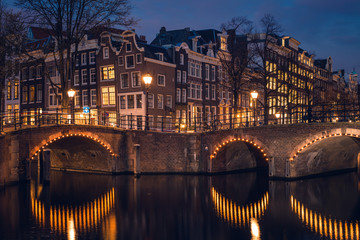Old historic houses, canal, and a bridge during twilight blue hour, Amsterdam, Netherlands