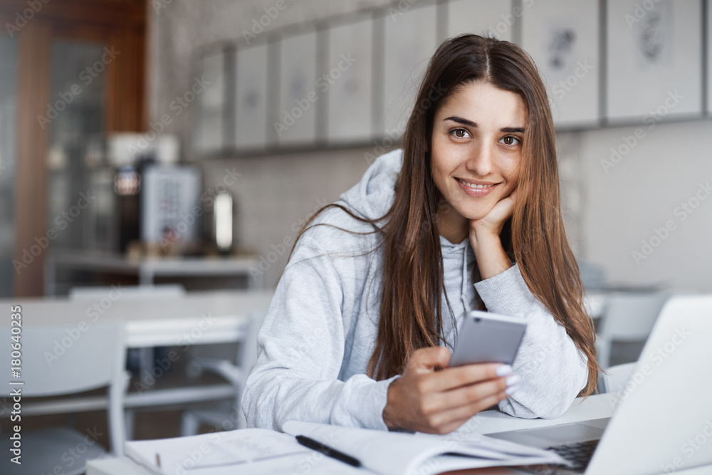 Aufkleber perfect young woman using smart phone and laptop computer browsing through photos looking at camera 