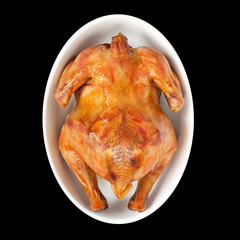 Grilled chicken on the white plate isolated on black