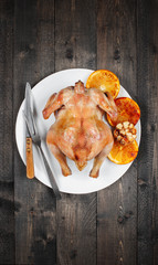 Grilled chicken with oranges and garlic in the white plate