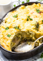 Gratin or Casserole in baking dish. Pasta fish cheese and vegetables.