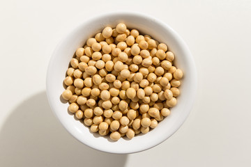 Soybean legume. Top view of grains in a bowl. White background