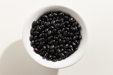 Black Turtle Bean legume. Top view of grains in a bowl. White background