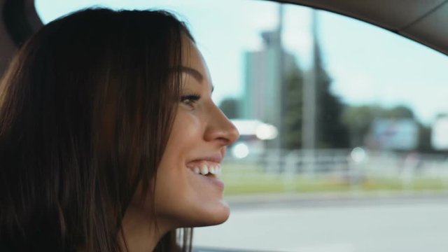 Portrait young caucasian attractive happy smiling woman sitting back seat car riding sightseeing city view background cheerful emotional face pretty female person traveling smile brunette long hair