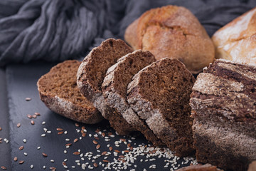Assortment of baked bread on dark background.