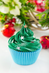 Green christmas cupcake with festive decorations