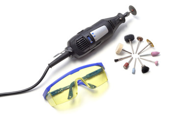 Mini drill with various nozzles and cutters on a white background