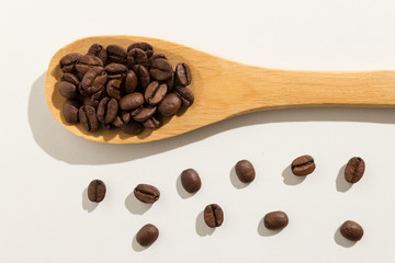 Fototapeta premium coffee beans seed. Healthy grains on a wooden spoon. White background.