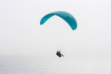 Blue paraglider over Lima, Peru