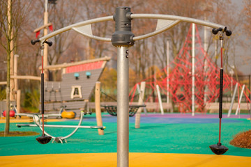 Modern equipped kids playground in sunny day. Balance carousel
