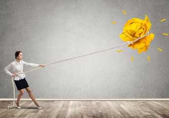 Businesswoman pulling paper ball with rope and making it raise up