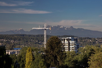 New construction of high-rise buildings in the city on the background of mountain range