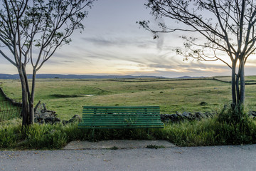 wooden bench to the evening in the pastures of the range of Saint Peter in Caceres, Spain.