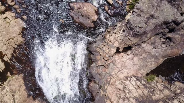 Drone flying over flowing water of waterfall