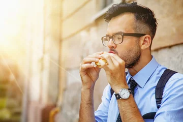 Foto op Aluminium  Hungry businessman eating sandwich. (Manager, worker, break, food, lLunchtime concept) © zwiebackesser