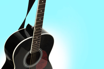 Fototapeta na wymiar Black acoustic guitar on a blue background