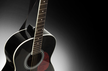 Fototapeta premium Black acoustic guitar on a black background