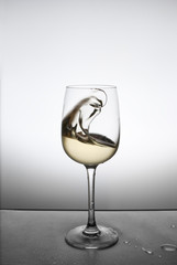 splash of white wine in a glass