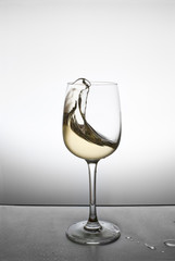 splash of white wine in a glass