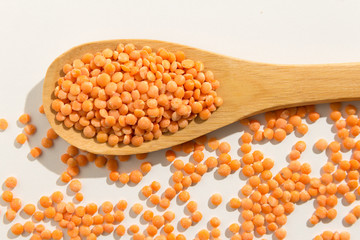 Turkish Red Lentil legume. Healthy grains on a wooden spoon. White background.