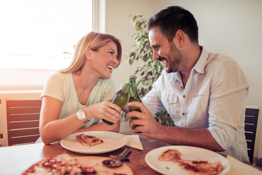 Couple Eating Pizza Snack At Home.