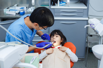 Dentist at work. Doctor cleaning little girl's teeth. Pediatric dentistry, prevention dentistry concept