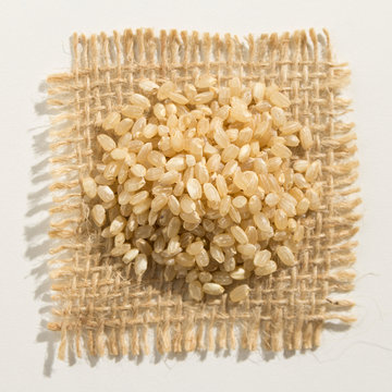 Whole Short Grain Rice Seed.  Close up of grains over burlap.
