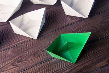 Business leadership concept with white and color paper boats on 