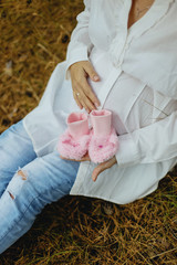 A pregnant woman holds the little booties for your unborn baby
