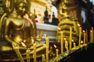 Candle light in front of buddha image.