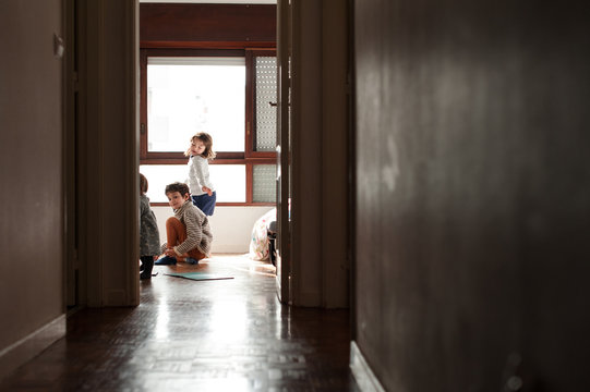 siblings playing on the floor in their home