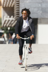 Handsome afro man riding a bike.