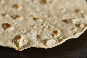 A corn tortilla cooking on a comal